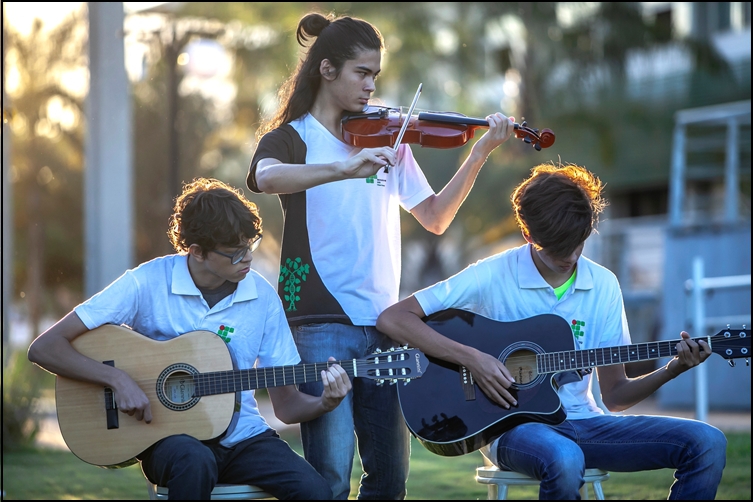 Ex-alunos treinando violão e violino em um fim de tarde no Câmpus Ex-alunos treinando violão e violino em um fim de tarde no Câmpus